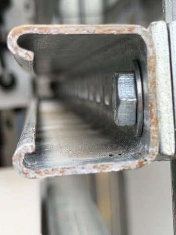 Cut strut ends left untreated and already corroding.