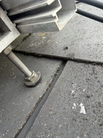 Roof fixing through a cracked tile, with no weatherproofing.